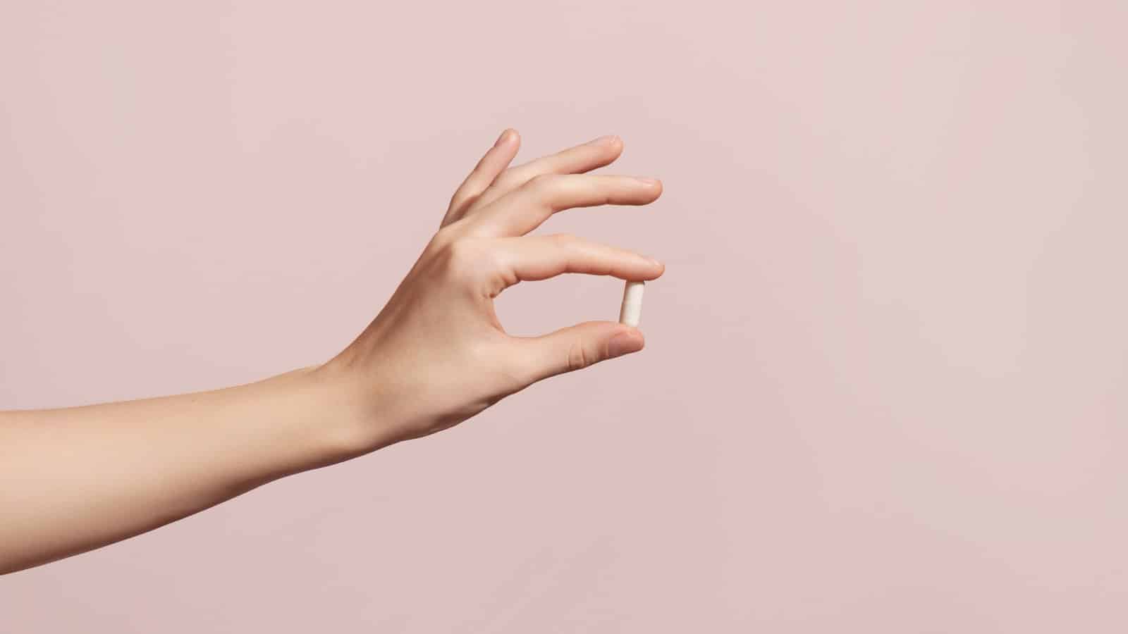 hand taking anti-aging longevity supplement