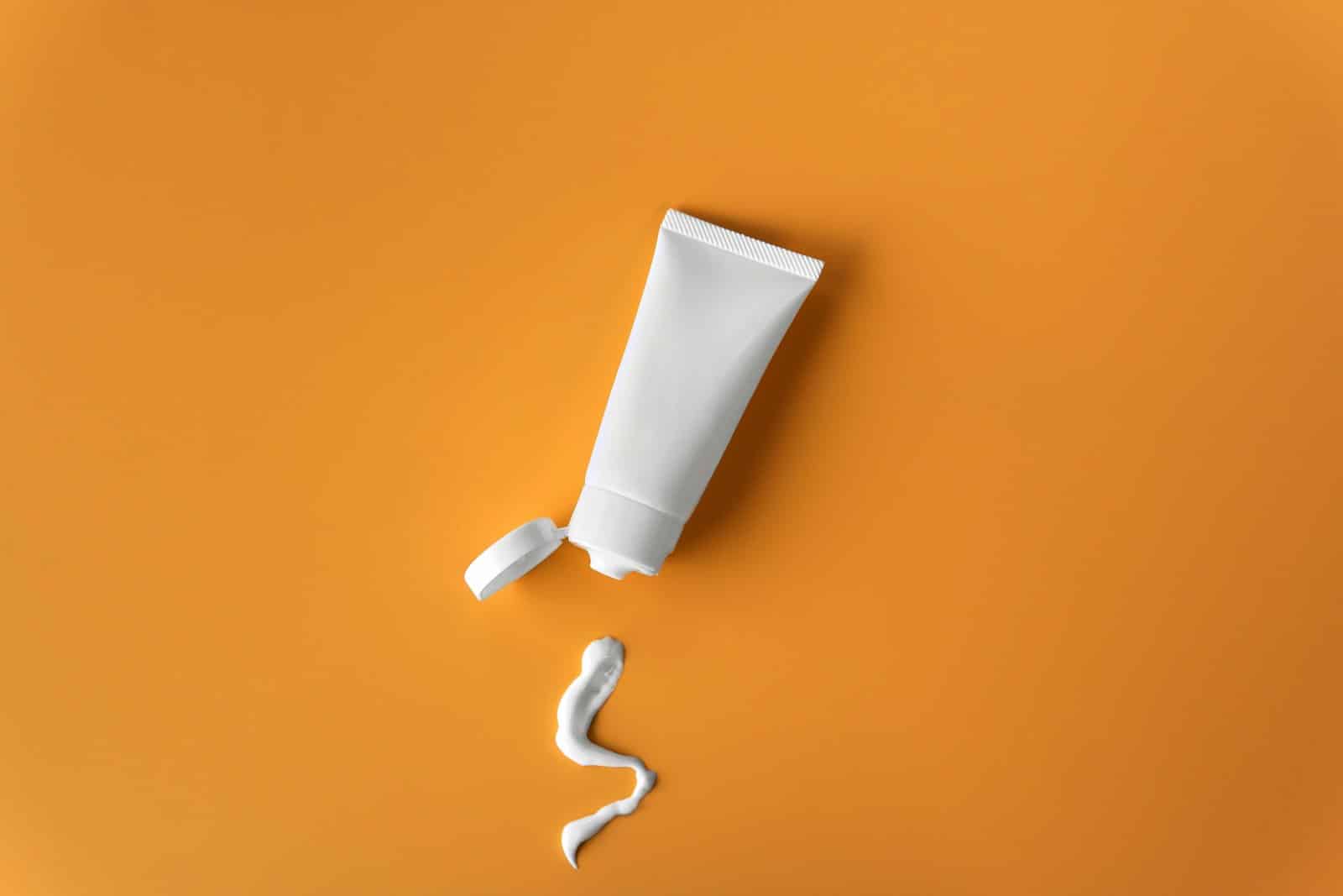 white skin care tube on orange background
