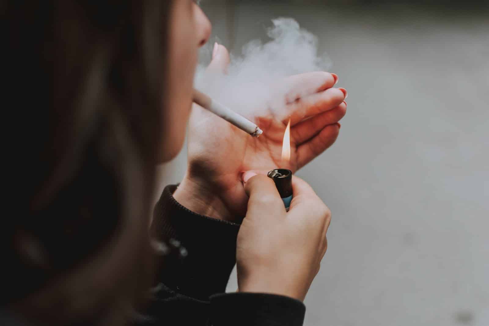 young woman lightning cigarette and smoking
