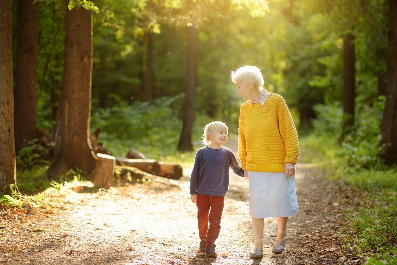 Grandmother and grandchild walking in forest